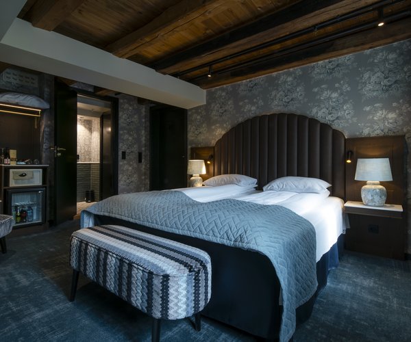 Double bed beneath exposed beams in the standard room