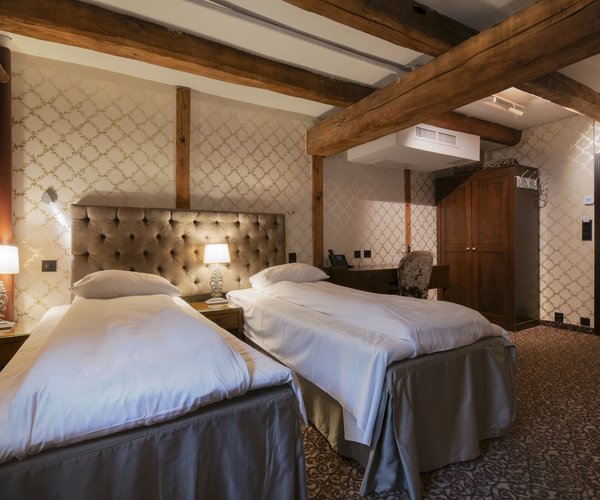 Deluxe room with double bed and wood-panelled walls