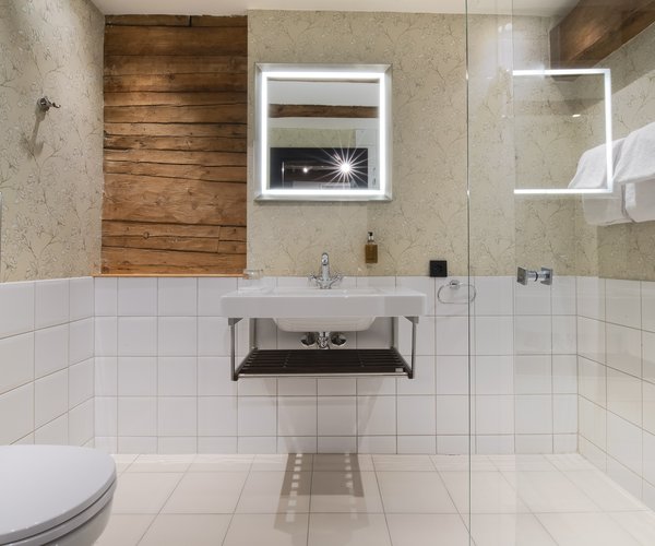 Bath and washbasin in the deluxe room's tiled bathroom