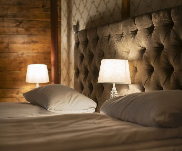 Double bed with quilted headboard and bedside lamps