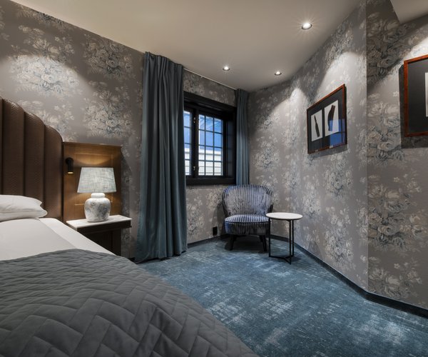 Deluxe room with double bed and blue carpet
