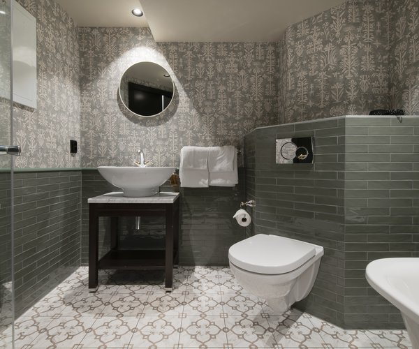 Washbasin with round mirror in the deluxe room bathroom