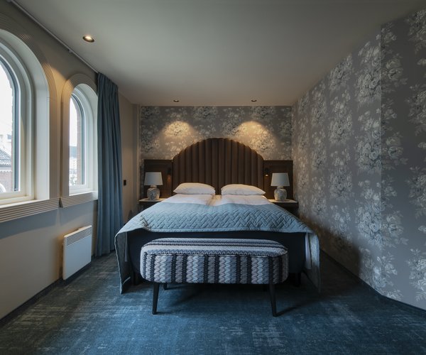 Double bed beneath the arched window in the deluxe room