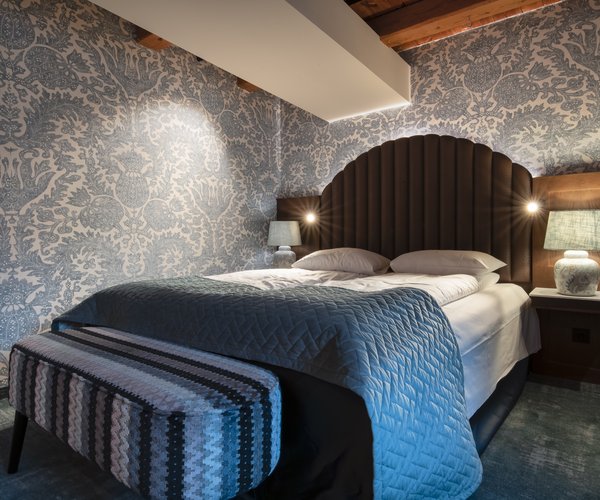 Double bed with upholstered headboard in the deluxe room