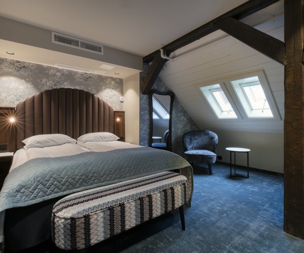 Double bed under the sloping ceiling with skylight