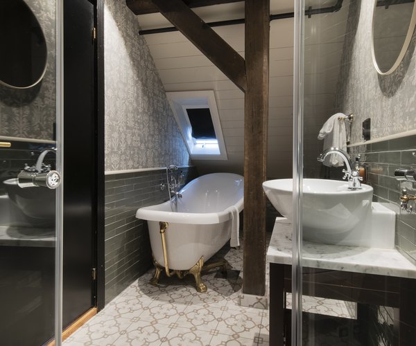 Bath and washbasin in the bathroom with round window