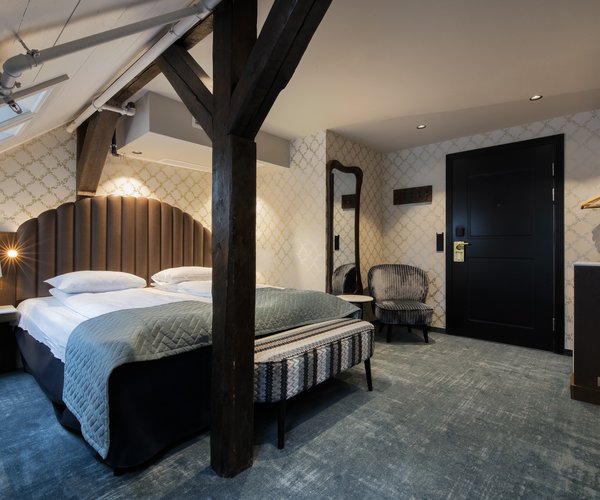 Double bed beneath the skylight in the deluxe room with sloped ceiling