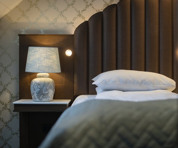 Bed with upholstered headboard and reading lamp