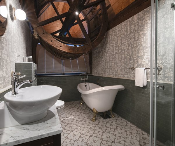 Bathroom with round window in the deluxe room with sloped ceiling