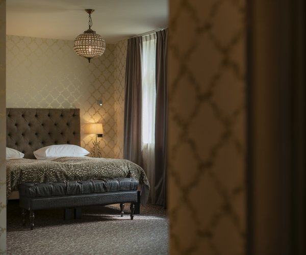 Junior suite with double bed and dark panelled wall