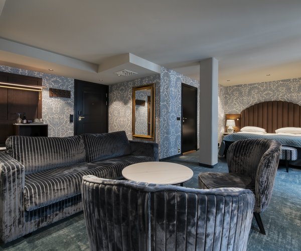 Armchairs and table beside the bed in the junior suite