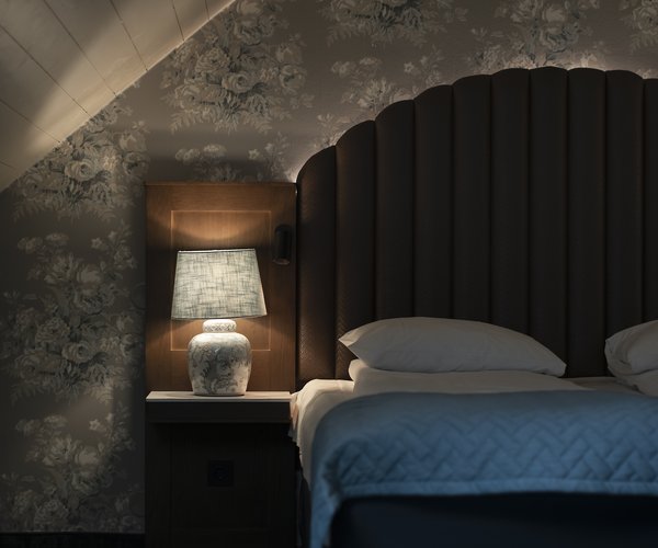 Double bed with arched headboard in the junior suite