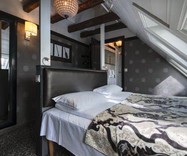 Double bed with patterned throw beneath the sloping ceiling