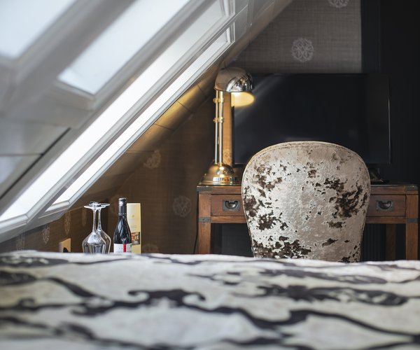 Bed with patterned bedding under the sloping ceiling