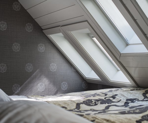 Double bed with white linen beneath the skylight