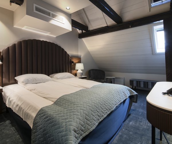 Double bed with arched headboard in the standard room