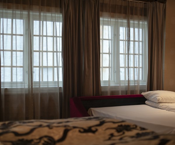 Bed beside tall windows in the suite