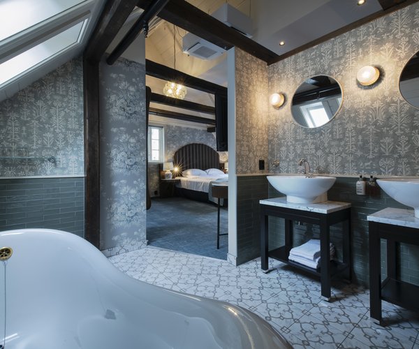 Free-standing bath and desk area in the open-plan suite