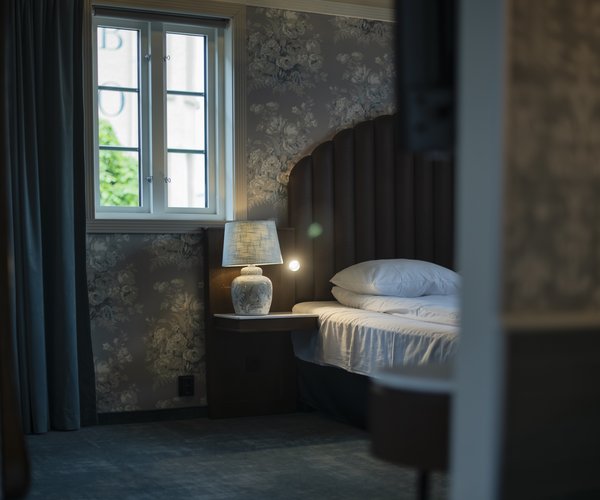 Bed beside the suite's window with heritage panes